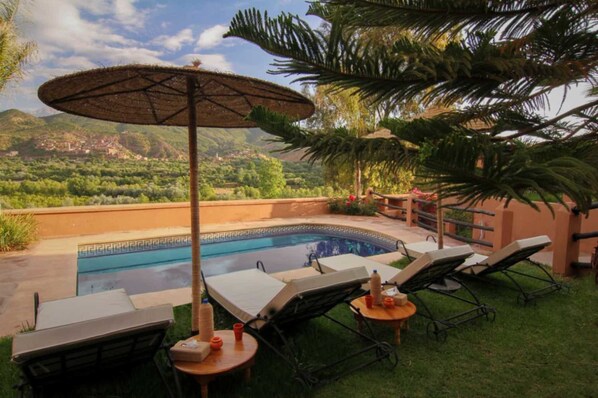 Utomhuspool, parasoller och solstolar