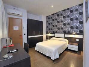 A hotel room with a bed, bedside tables, a desk, and a wardrobe. - Hotel Daymiel (Daimiel)