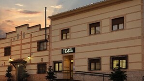 Un hotel con fachada tradicional, múltiples ventanas y un cartel que indica que es un hotel.