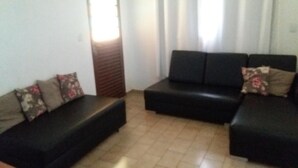 Una sala de estar con un sofá modular y un sillón pequeño.