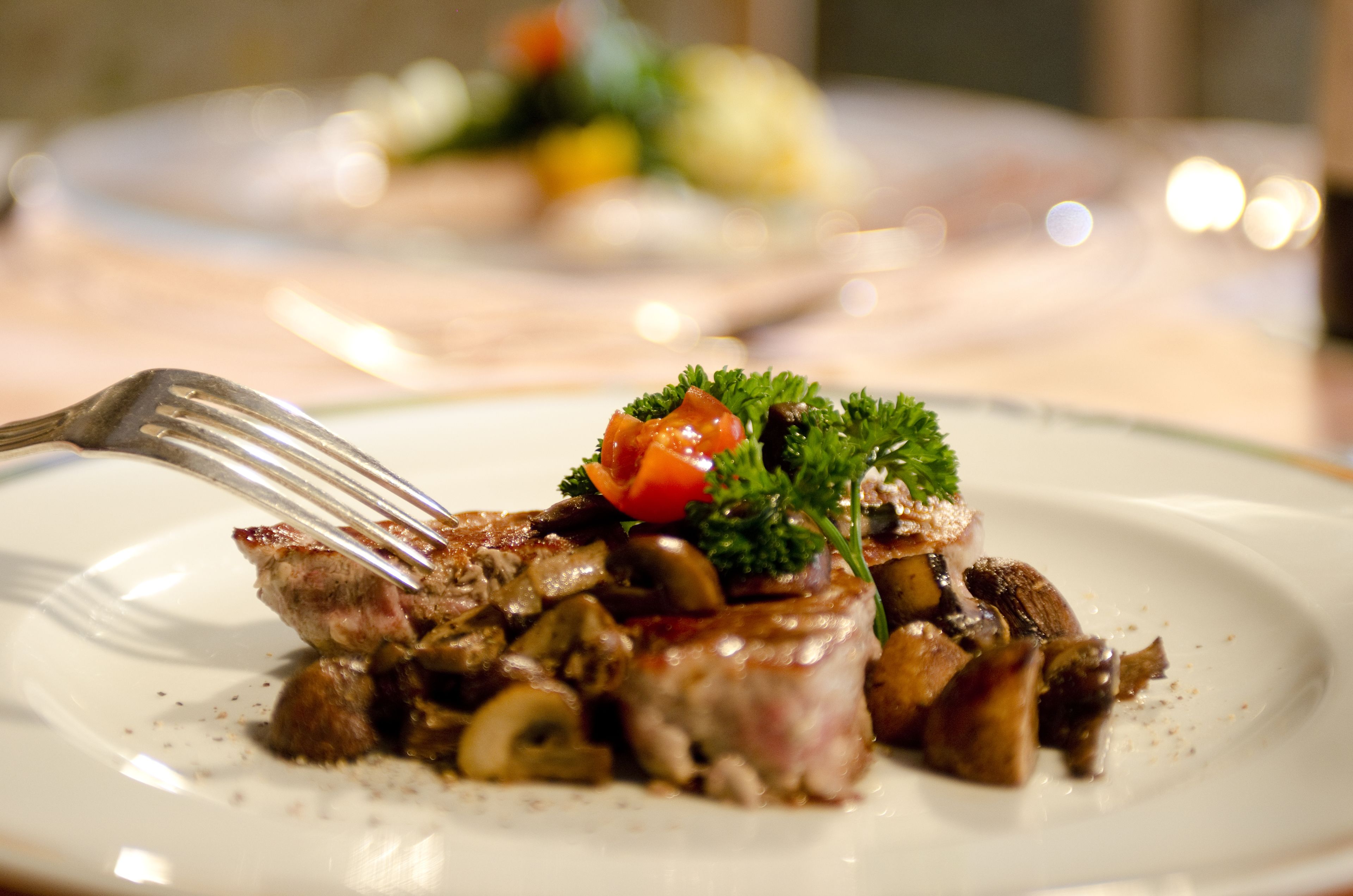 Une vue rapprochée d’une assiette contenant un steak, des champignons et diverses garnitures.