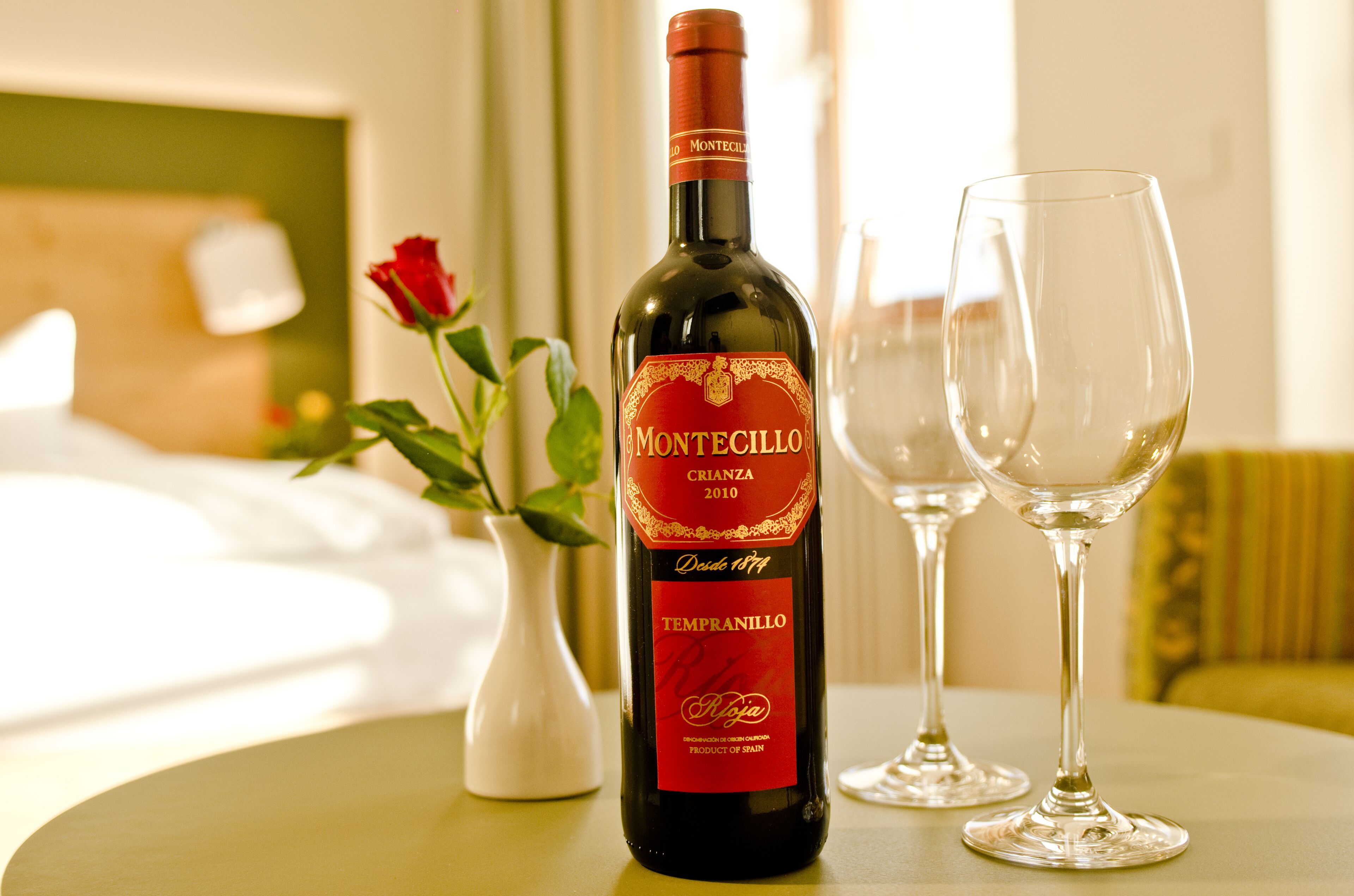 Una ampolla de vi Montecillo Crianza 2010 i dues copes de vi buides sobre una taula.