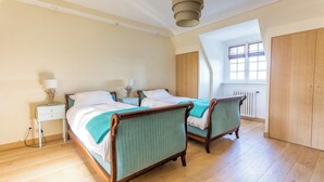 A bedroom with two beds, a nightstand, a lamp, a window, and a wardrobe. - Homerez - Villa in Roscoff, sea view (Roscoff)