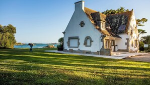 A white building with a steep roof, a small porch, and a view of the sea. - Homerez - Villa in Roscoff, sea view (Roscoff)