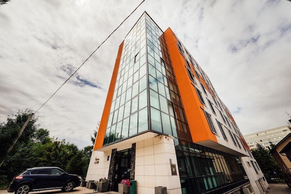 A modern building with a glass facade and orange accents.