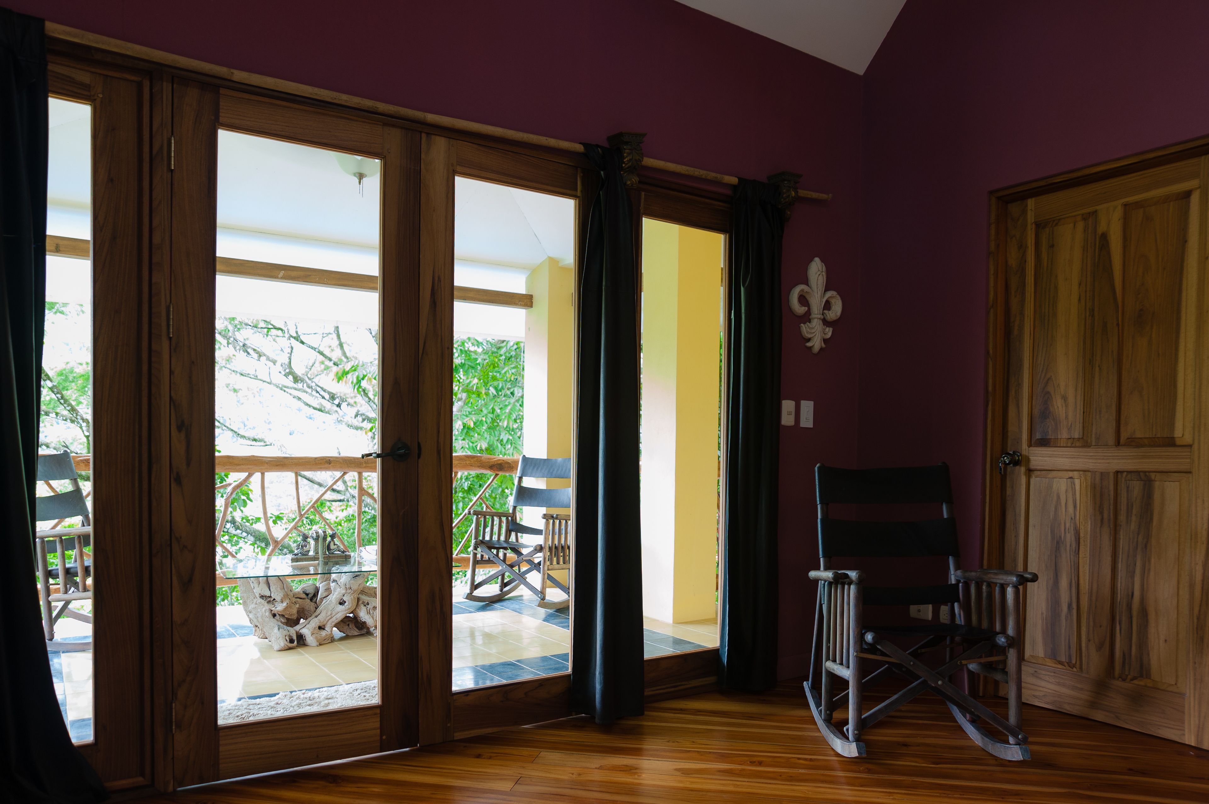 A room with a sliding glass door leading to an outdoor area with a wooden table and chairs.
