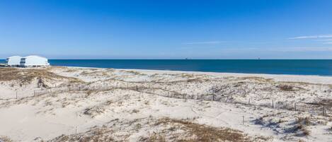 A beach with white buildings and a clear blue sky.