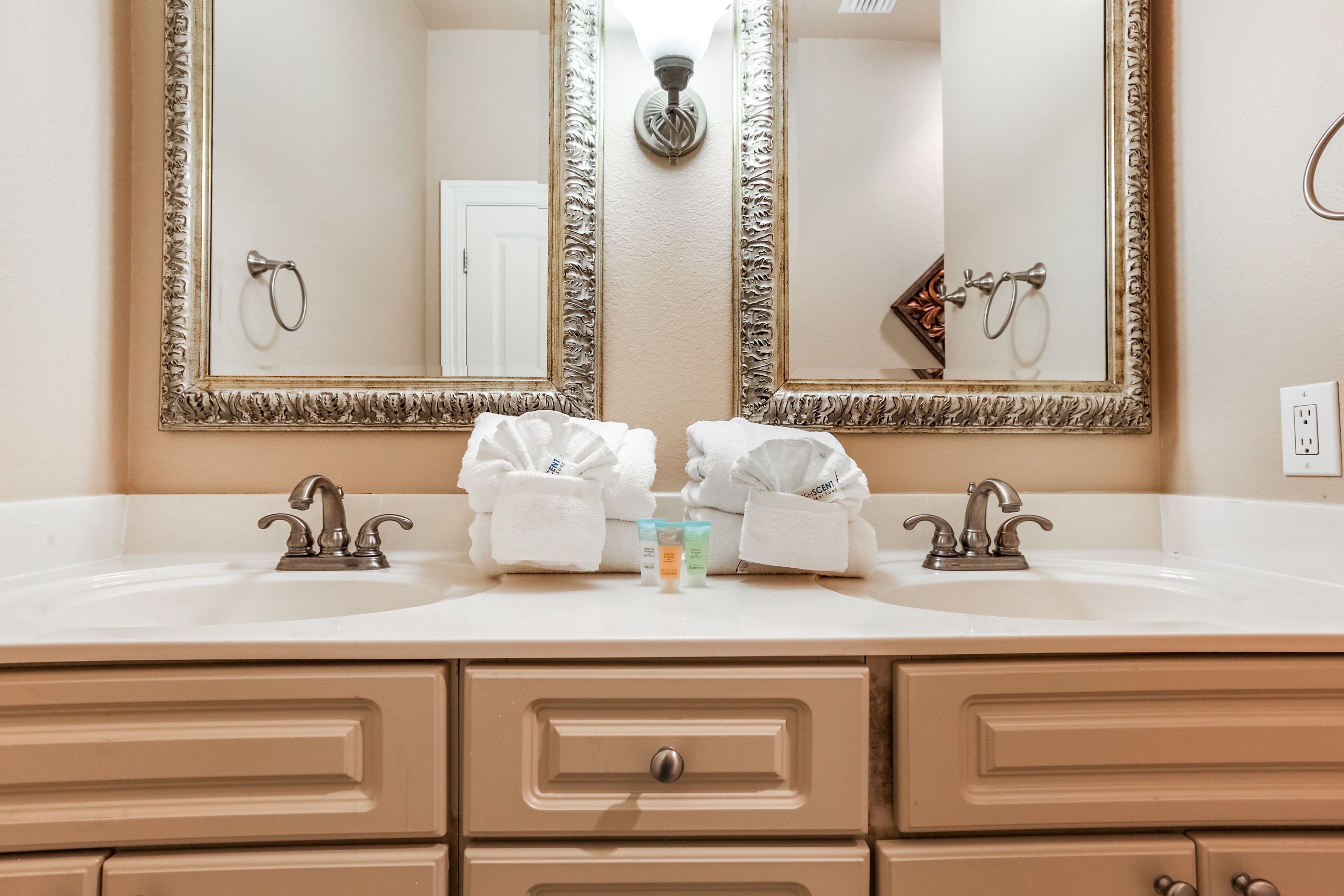 A bathroom with two sinks, a large mirror, and a towel rack.