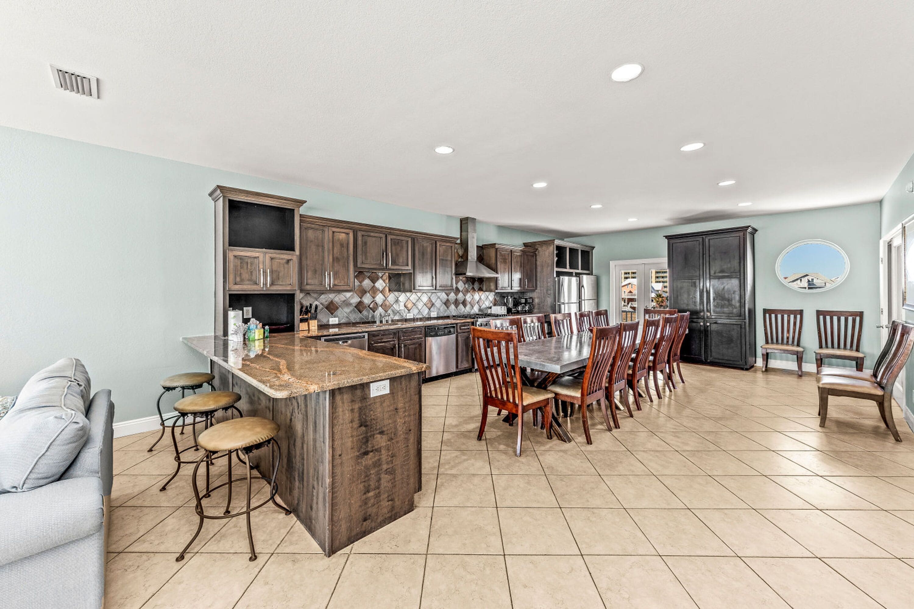 A spacious kitchen with a central island, dining area, and built-in appliances.