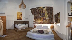 Un dormitorio moderno con una cama grande, una bañera y una pared decorada con un cuadro de gran tamaño.