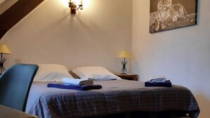 A bedroom with a bed, two bedside tables with lamps, a wall-mounted light fixture, and a framed picture. - Domaine des Garennes (Nadaillac)