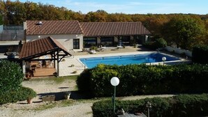 A building with a swimming pool, a covered patio, and a garden area. - Domaine des Garennes (Nadaillac)