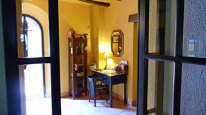 A room with a desk, chair, and a wooden cabinet with decorative items.