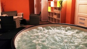 Quarto com banheira de hidromassagem, um relógio na parede e um aparador com plantas.