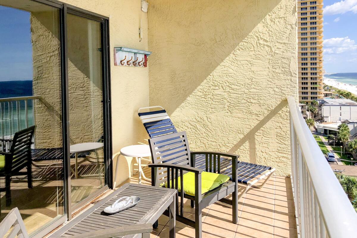 Een balkon met een tafel, twee stoelen en twee comfortfauteuils.