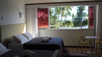 Quarto de hotel com duas camas, uma mesinha e uma cadeira.