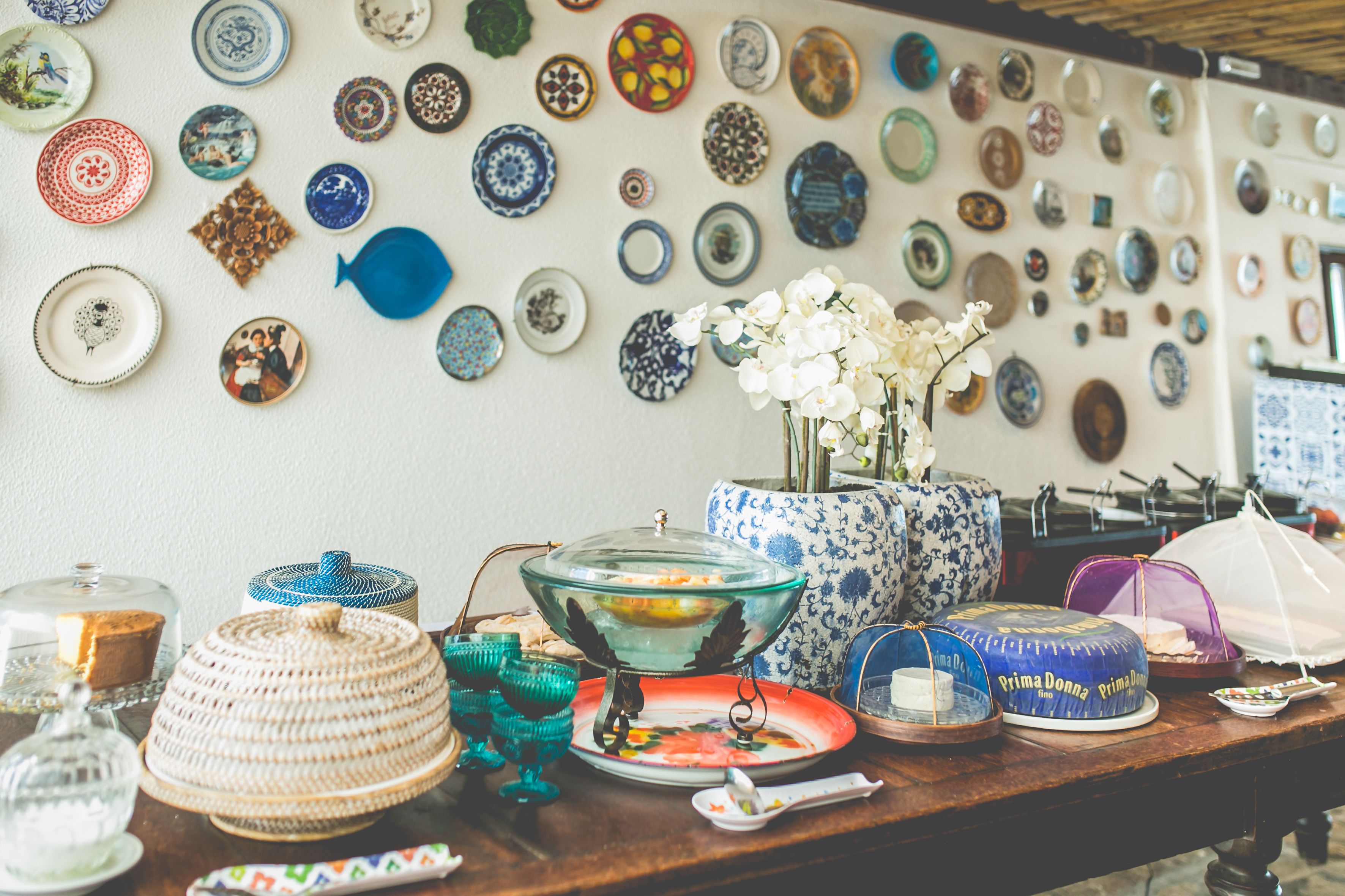 A table with various dishes and a wall decorated with numerous plates.