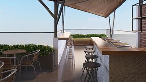 A rooftop bar with a long counter, bar stools, and outdoor seating. - Moonlight Bay Hotel (Bac Nha Trang)
