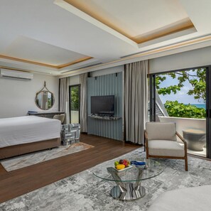 A hotel room with a bed, TV, seating area, and a balcony with a view. - The Boathouse Phuket (Karon)