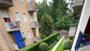 A residential building with a curved staircase, a well-maintained garden with a stone pathway, and neatly trimmed hedges. - Villa Terri (Verona)