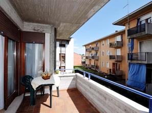 A balcony with a table and chairs, overlooking a residential area with multi-story buildings. - Villa Terri (Verona)