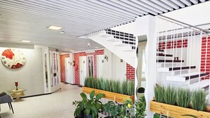Un interior moderno con techo blanco, una escalera en espiral y plantas en macetas.