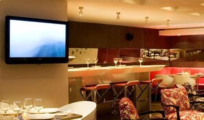 Ein Restaurant mit Barbereich, mehreren Tischen und Stühlen.