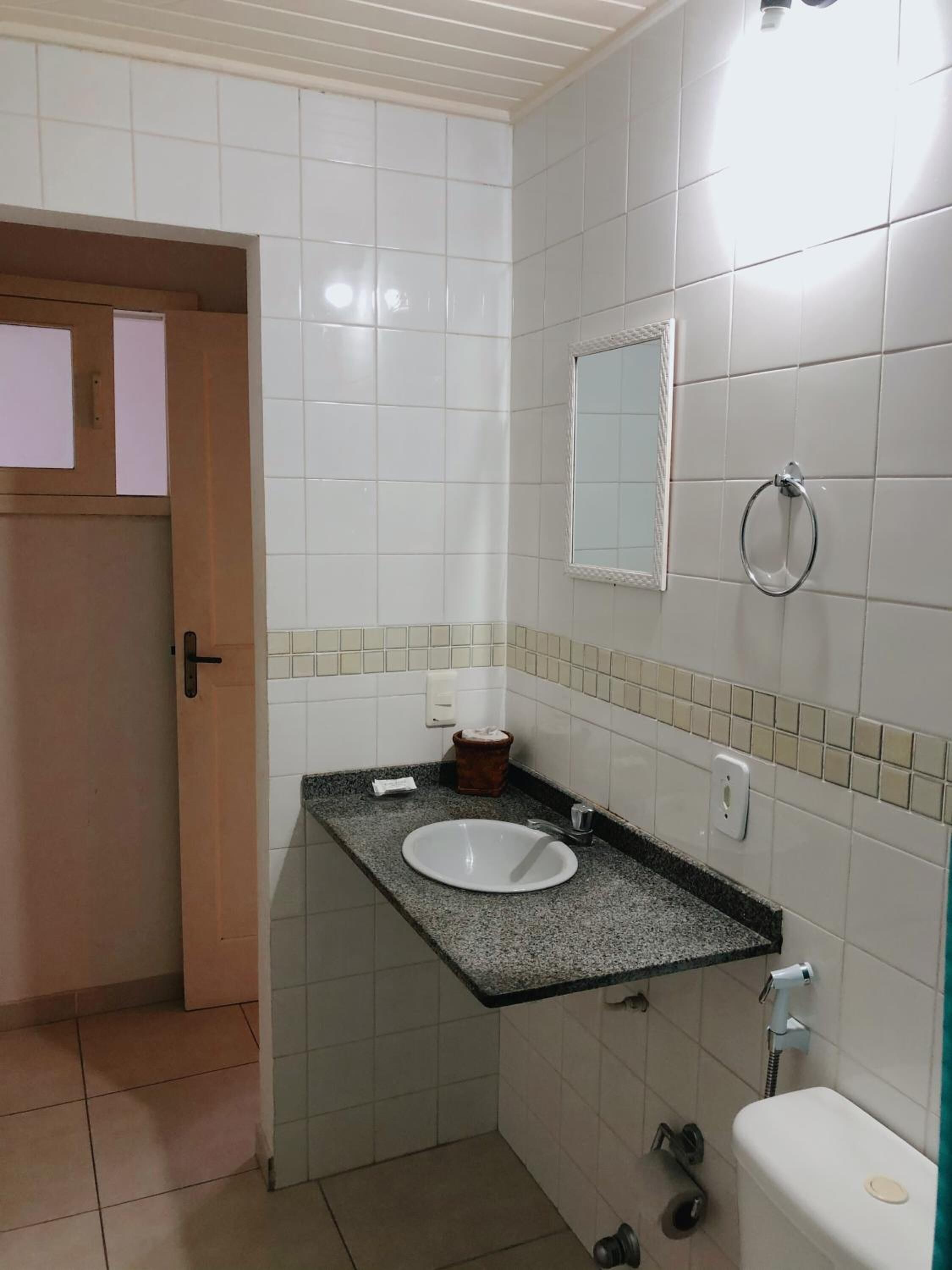 A bathroom with a white sink, a mirror, and a toilet.