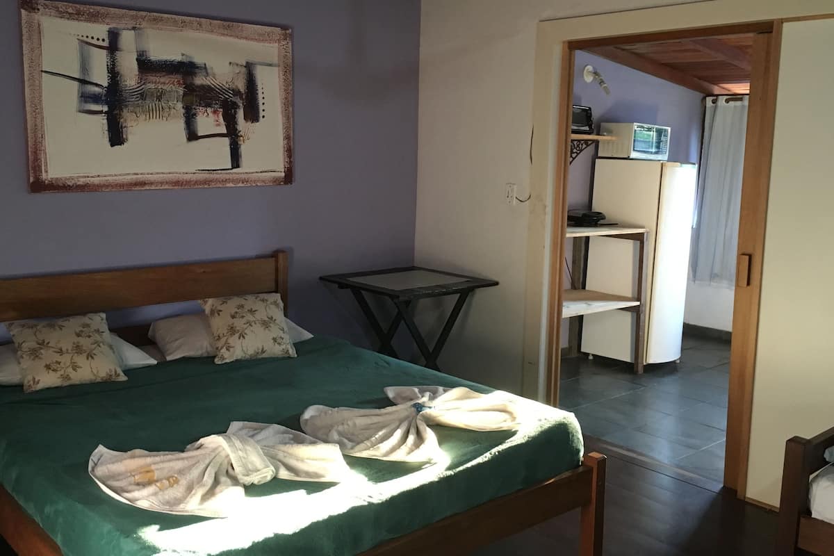 Une chambre à coucher avec un lit, une table et un tableau accroché au mur.