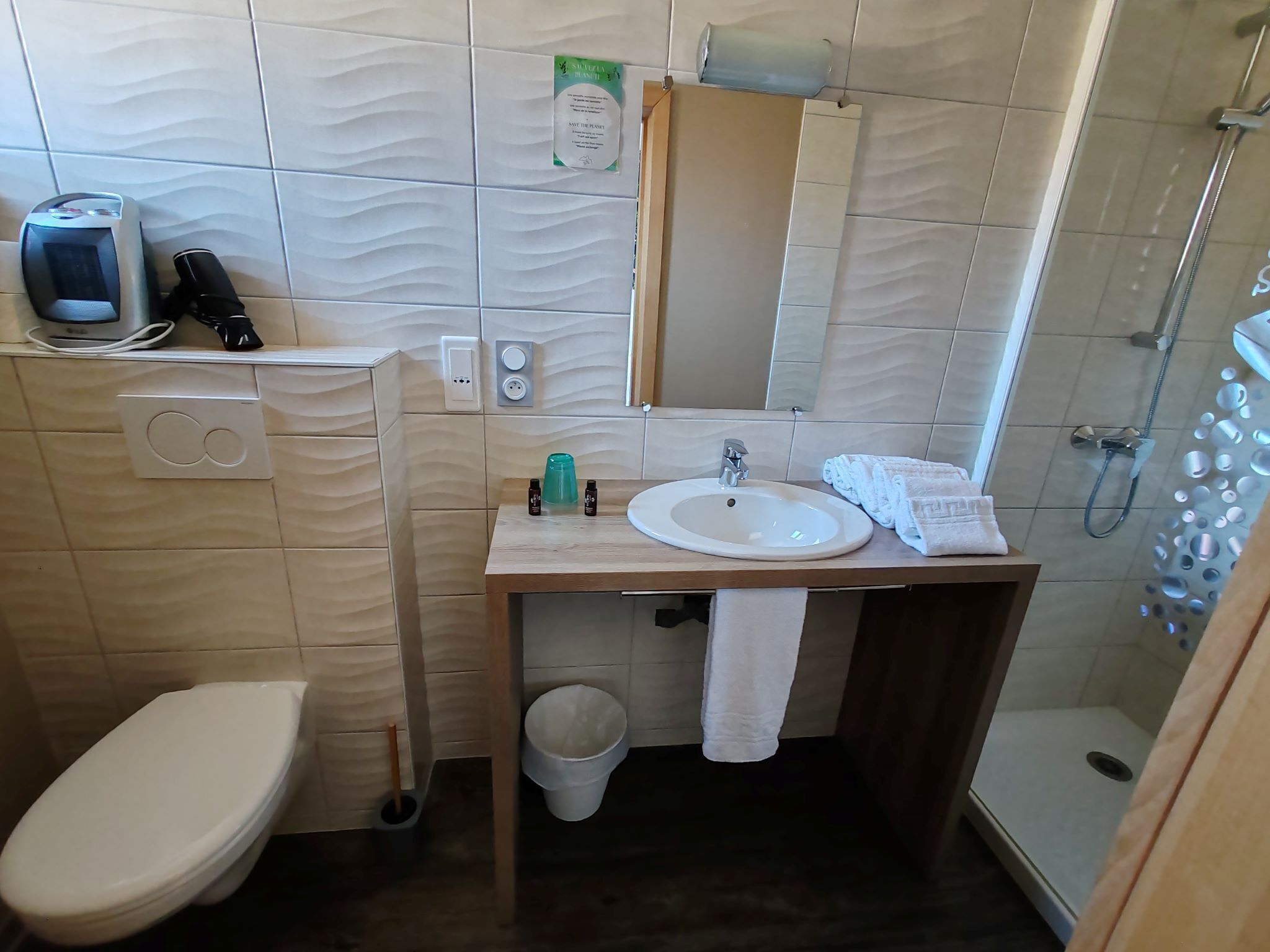 Une salle de bain avec des toilettes, un lavabo et une douche.
