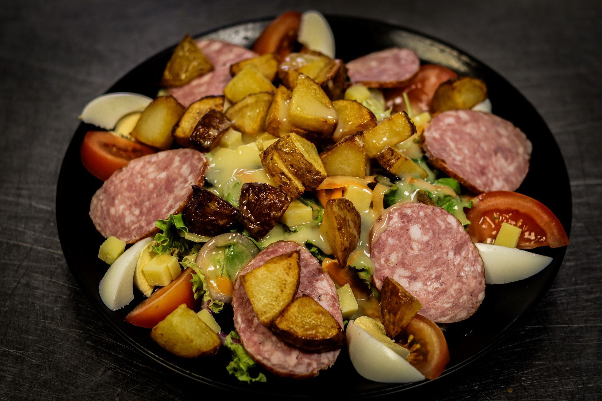 A plate of food with various items including potatoes, sausages, and vegetables.