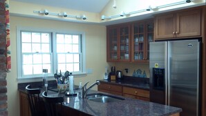 A kitchen with a granite countertop, stainless steel appliances, wooden cabinets, and a window with blinds. - 5BR-Beautiful Chatham-Year Round-Sleeps up to ten (10) & 1 Mile to Town! (Chatham)
