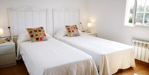 A room with two single beds, white bedding, a white headboard, bedside lamps, a window with a view, and a radiator. - ROSERS - House with private pool, barbecue 20 minutes Barcelona (Cabrils)