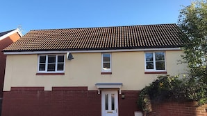 A two-story house with a tiled roof, a front door, and two windows. - Mayflower Coach House (Hereford)