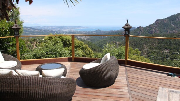 A wooden deck with wicker furniture and a view of a mountainous landscape. - Stunning Views Over The Bay Of Cannes (Fréjus)