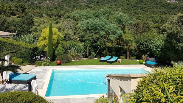 Une piscine dotée de chaises longues et offrant une vue sur un paysage montagneux.
