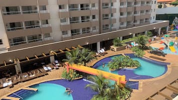 Relax by the rooftop pool surrounded by lush greenery and lounge chairs.