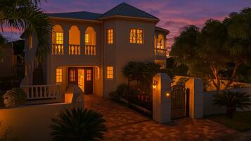 A two-story house with a front entrance, a covered porch, and a gated driveway.