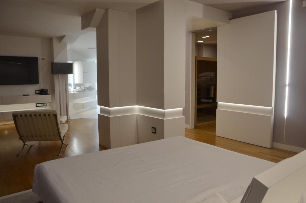 Una habitación de hotel moderna con cama, televisor de pantalla plana, escritorio y silla.