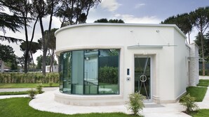 Un edificio moderno de una sola planta con grandes ventanales y fachada curva.