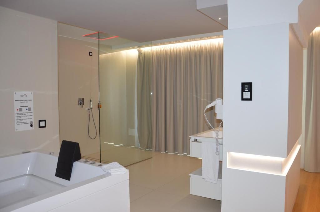 A modern bathroom with a bathtub, a shower area, and a vanity with a mirror.