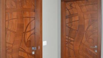 A hallway with two wooden doors featuring intricate designs.