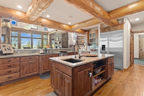 A spacious kitchen with wooden beams, granite countertops, and a stainless steel refrigerator. - Nearby River Run and the Gondola, Covered Patio w/Hot Tub, Media/Game Room (Keystone)