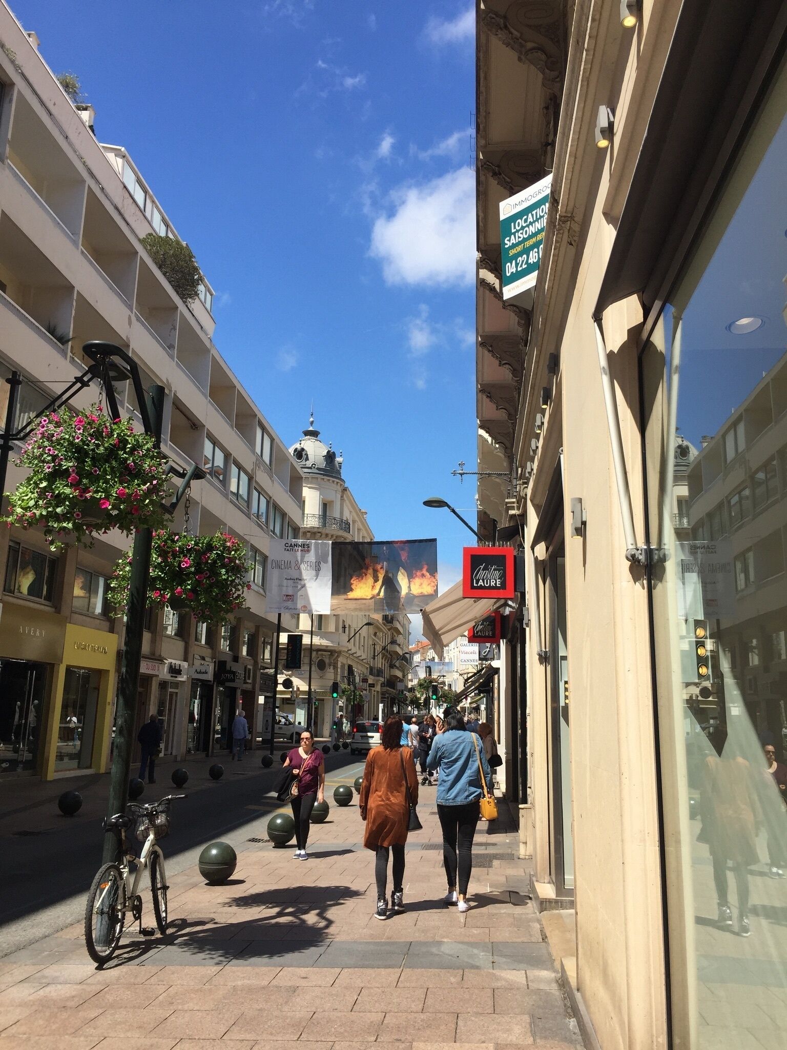 Una calle con tiendas y un edificio con cúpula.