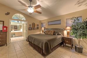A bedroom with a bed, a nightstand, a lamp, a ceiling fan, a potted plant, and a dresser. - Charming 3 Bedroom Home with Heated Saline Pool Located, Ahwatukee Phoenix (Phoenix)