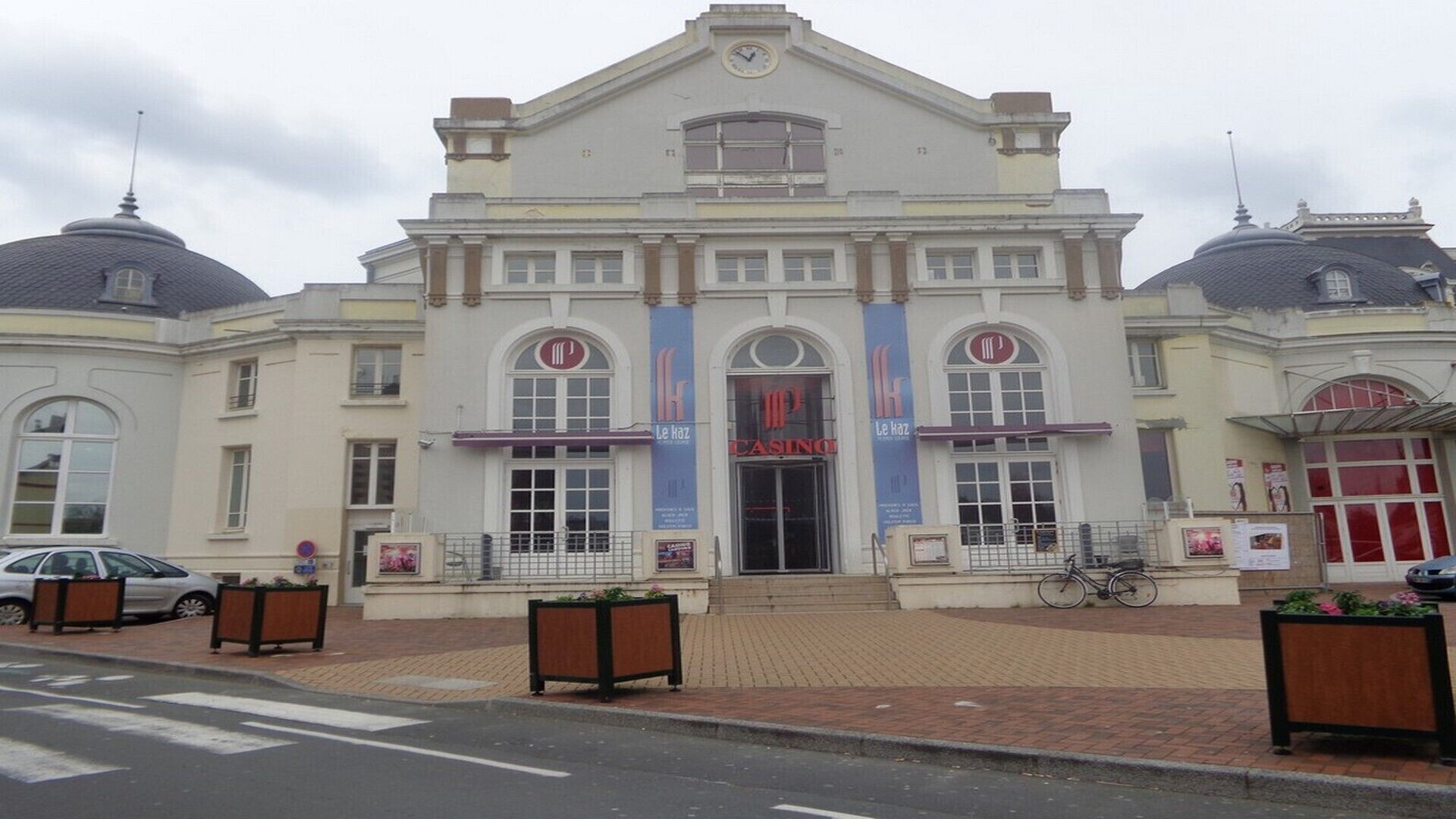 Um edifício com um grande letreiro de cassino, amplas janelas e fachada simétrica com duas cúpulas.
