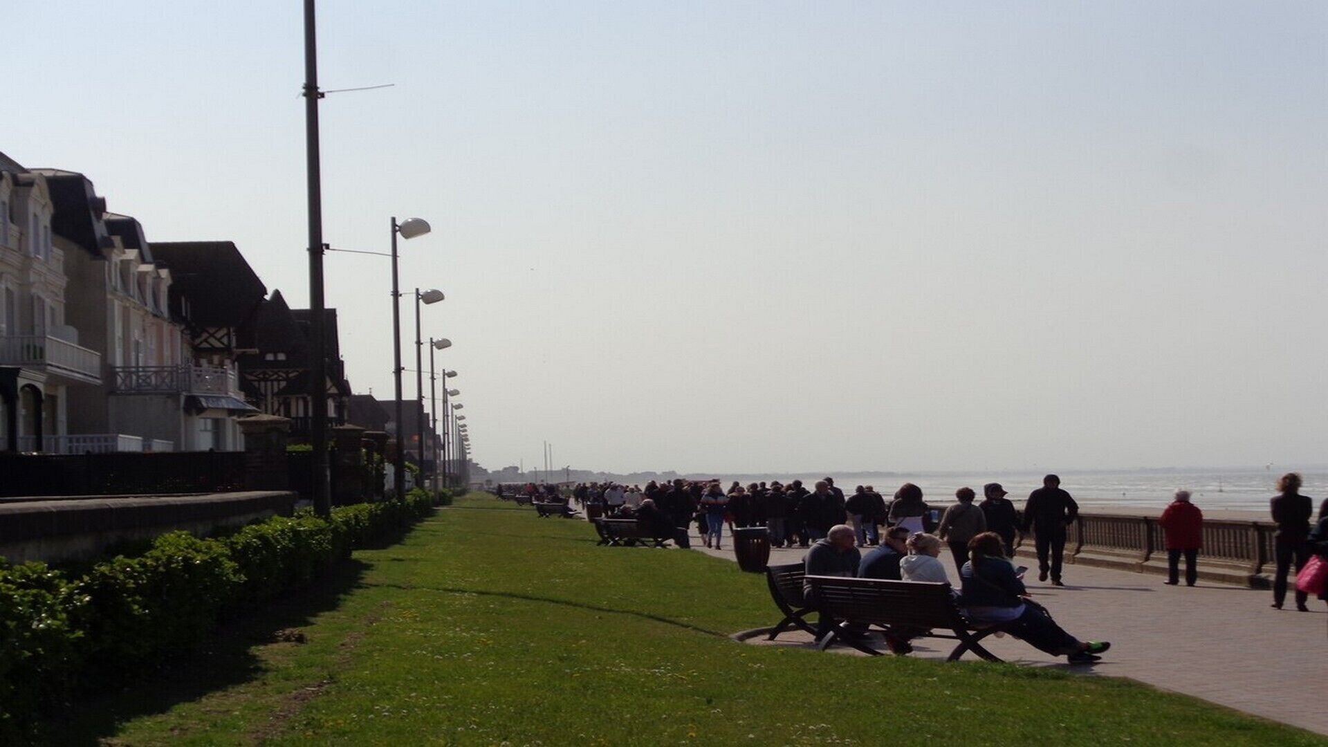 Eine Promenade mit Bänken und Spaziergängern.