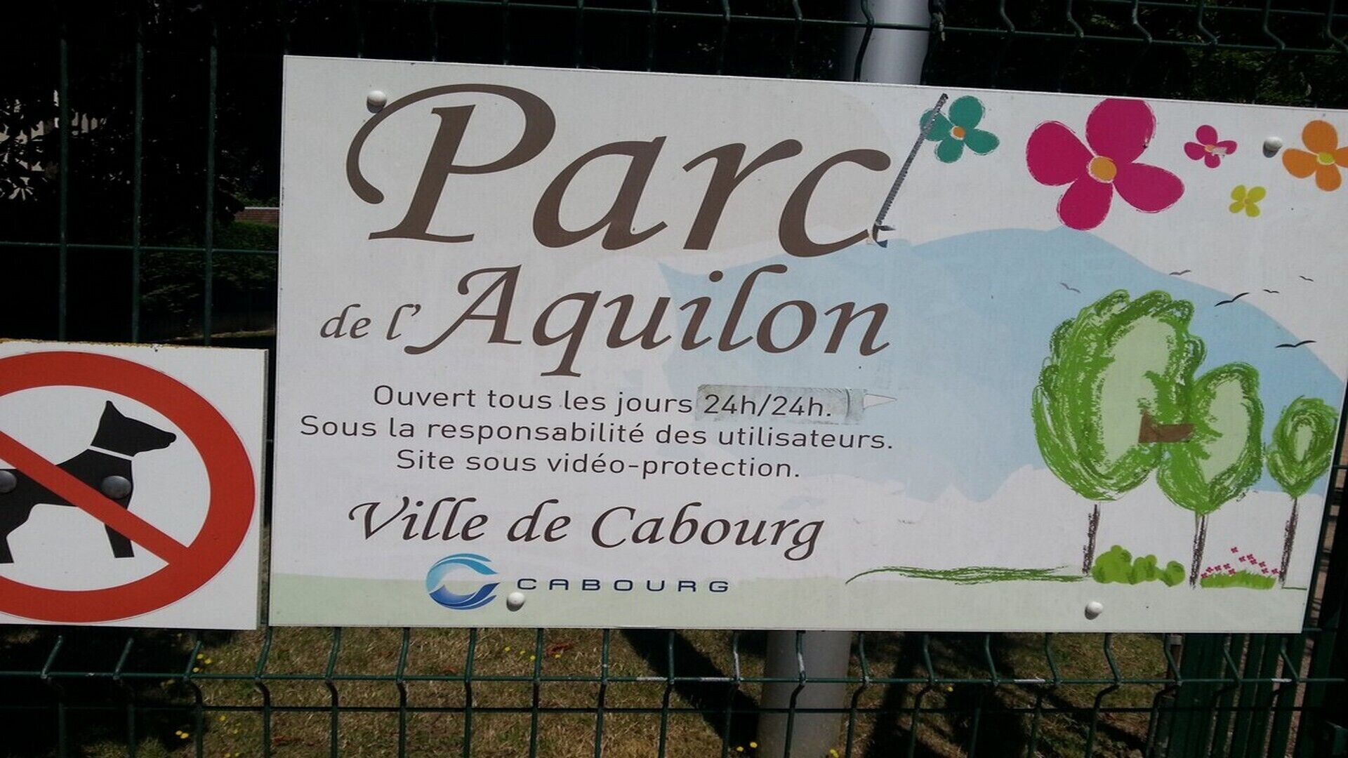 A sign for Parc de l'Aquilion with text indicating it is open 24 hours and under user responsibility.