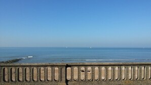 A coastal view with a stone railing and the sea in the background.