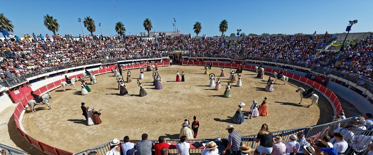 Una plaza de toros con espectadores sentados alrededor del ruedo.